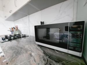 Light Apartment في ريغا: وجود ميكروويف للجلوس على منضدة في المطبخ
