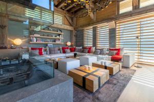 a large living room with white furniture and red pillows at Chalet Le Nolde in Mussillon
