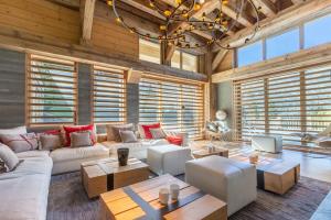 a living room with white furniture and wooden ceilings at Chalet Le Nolde in Mussillon