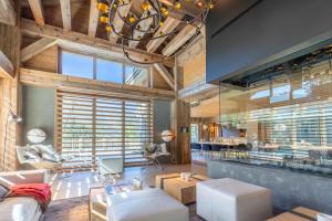 a living room with a chandelier and wooden ceilings at Chalet Le Nolde in Mussillon