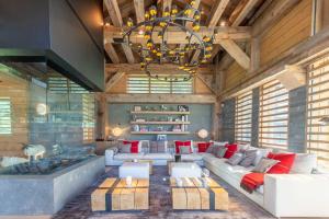 a living room with a large couch and a chandelier at Chalet Le Nolde in Mussillon