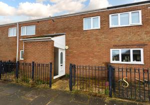 a brick house with a white door and a gate at Luke Stays - Hareydene in Lemington