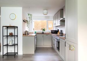 uma cozinha com armários brancos e pisos em madeira em Luke Stays - Hareydene em Lemington