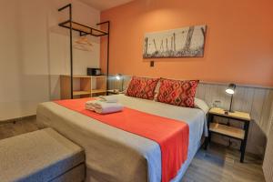 ein Hotelzimmer mit einem Bett mit orangefarbenen Wänden in der Unterkunft Hotel Bariloche By Tierra Gaucha in San Carlos de Bariloche