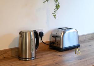 a toaster and toaster sitting on a wooden floor at Luke Stays - Hareydene in Lemington