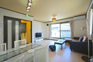 uma sala de estar com uma mesa e um sofá em Maple Hotel Osaka em Osaka