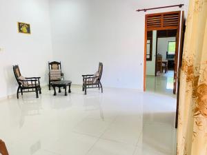 a room with chairs and a table on a tile floor at White Villa in Weligama +26 photos