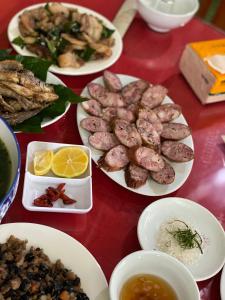 une table avec des assiettes de nourriture sur une table rouge dans l'établissement Mai Anh Homestay - Pac Bo Village, 