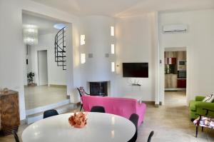 - un salon avec une table et des chaises roses dans l'établissement Villa Cossyra, à Porto Palo