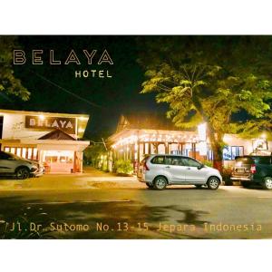 a car parked in a parking lot in front of a hotel at Belaya Hotel in Jepara