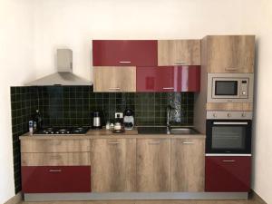 - une cuisine avec des placards en bois, une cuisinière et un four micro-ondes dans l'établissement Villa Cossyra, à Porto Palo