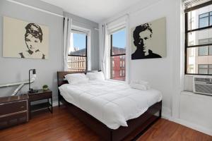 um quarto com uma cama grande e 2 janelas em Central and Great Location 1BR 15min to NYC em Hoboken