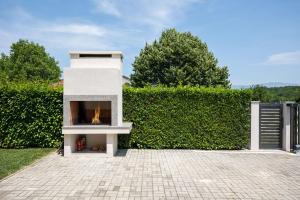 a fireplace in front of a green hedge at Villa Fila in Sinj