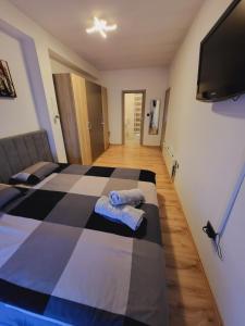 a bedroom with a checkered bed with towels on it at Apartman TARA in Zagreb