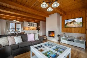 a living room with a couch and a table at Chalet Bystra - wellness 5 min-washer-game room-view-5 bedrooms in Mýto pod Ďumbierom
