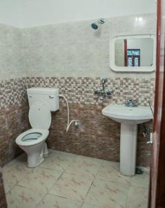 een badkamer met een toilet en een wastafel bij Rama Guest House in Bodh Gaya