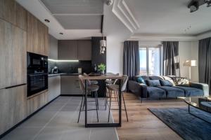 a kitchen and living room with a couch and a table at Sunrise Sky Lux Apartment, 33rd floor, Pool and Fitness Included in Skopje