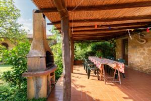 patio al aire libre con mesa y estufa de leña en Borgo De Salaioli, en Scansano