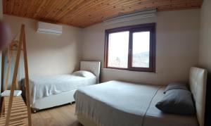 a bedroom with two beds and a window at Villa Pamuklu second floor only in Çaykara +18 photos