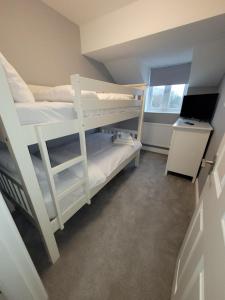 a bunk bed room with two bunk beds and a desk at Golden Valley View in Codnor