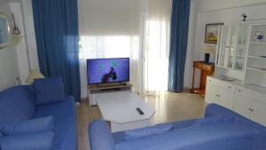 un soggiorno con divano blu e TV di Mountain View Apartment in Port Alcudia a Port d'Alcudia