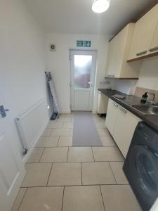 a small kitchen with a sink and a door at Golden Valley View in Codnor