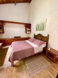 a bedroom with a large bed and a table at Casa da Ilha Paraty Entre a mata atlântica e o mar in Paraty