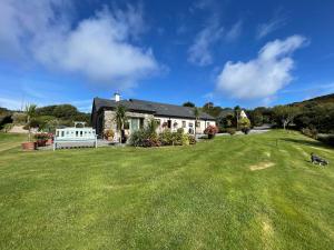 a house with a large lawn in front of it at The Garden Room at Sleepy Hollow in Louisburgh
