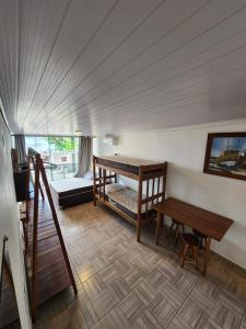Habitación con cama, escritorio y mesa. en Hospedaria Ilhabela - Flats Balsa, en Ilhabela