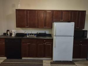 a kitchen with a white refrigerator and wooden cabinets at Jelly Bean 1 in St. John's