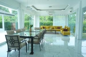 comedor con mesa de cristal y sillas en CoaSea Pool Villa - 3 Bedrooms 3.5 Bathrooms en Chumphon