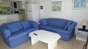 een woonkamer met een blauwe bank en een tafel bij Mountain View Apartment in Port Alcudia in Port d'Alcudia