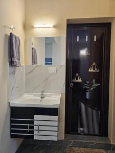 een badkamer met een wastafel en een spiegel bij Heavenly stay at wayanad in Kenichira