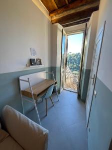 Habitación con mesa, silla y balcón. en Via Camerina 3, en Castelnuovo di Porto