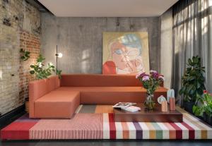 a living room with a orange couch and a painting at BURSA Hotel Kyiv in Kyiv