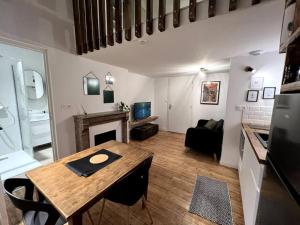 een woonkamer met een tafel en een open haard bij Studio 2 - Mi-Côte - Duplex à Orvault in Orvault