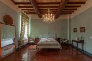 una camera con letto e lampadario a braccio di Villa Cairoli Gonzaga a Gonzaga