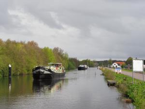 due barche sono ormeggiate su un fiume vicino a una strada di hotelboat Sarah Groningen a Groninga (Groningen)