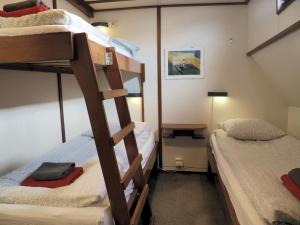 Habitación con litera, 2 camas y lámpara en hotelboat Sarah Groningen, en Groninga