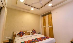 a bedroom with a bed and a ceiling fan at FabHotel The Royal Oak in Gurgaon