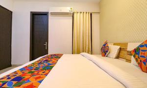 a bedroom with a large bed with a colorful blanket at FabHotel The Royal Oak in Gurgaon