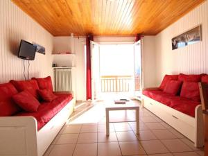 - un salon avec deux canapés rouges et une fenêtre dans l'établissement Appartement Huez, 2 pièces, 5 personnes - FR-1-405-153, à L'Alpe-d'Huez