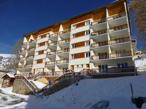 un grand bâtiment avec de la neige devant lui dans l'établissement Appartement Huez, 2 pièces, 5 personnes - FR-1-405-153, à L'Alpe-d'Huez