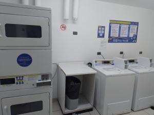 a kitchen with white appliances in a room at Santiago Apartotel Florida in Santiago