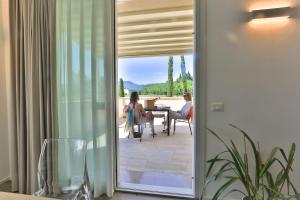 une porte menant à une terrasse avec des personnes assises à une table dans l'établissement Casa Massaro Todeschini, à Abano Terme