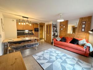 een woonkamer met een rode bank en een keuken bij Appartement Samoëns, 3 pièces, 6 personnes - FR-1-624-16 in Samoëns