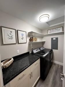 eine Küche mit einer schwarzen Arbeitsplatte in einem Zimmer in der Unterkunft Your Magnificent Riverfront Home in Woodland