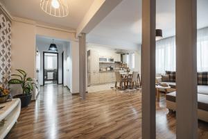 sala de estar de planta abierta y cocina con suelo de madera maciza en Olivia's Home, en Sibiu