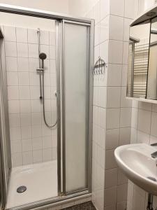La salle de bains est pourvue d'une douche et d'un lavabo. dans l'établissement Geräumige Wohnung Dortmund City, à Dortmund