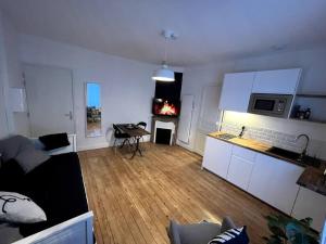 a kitchen and living room with a fire in the fireplace at Studio 3 - Mi-Côte - Studio à Orvault in Orvault